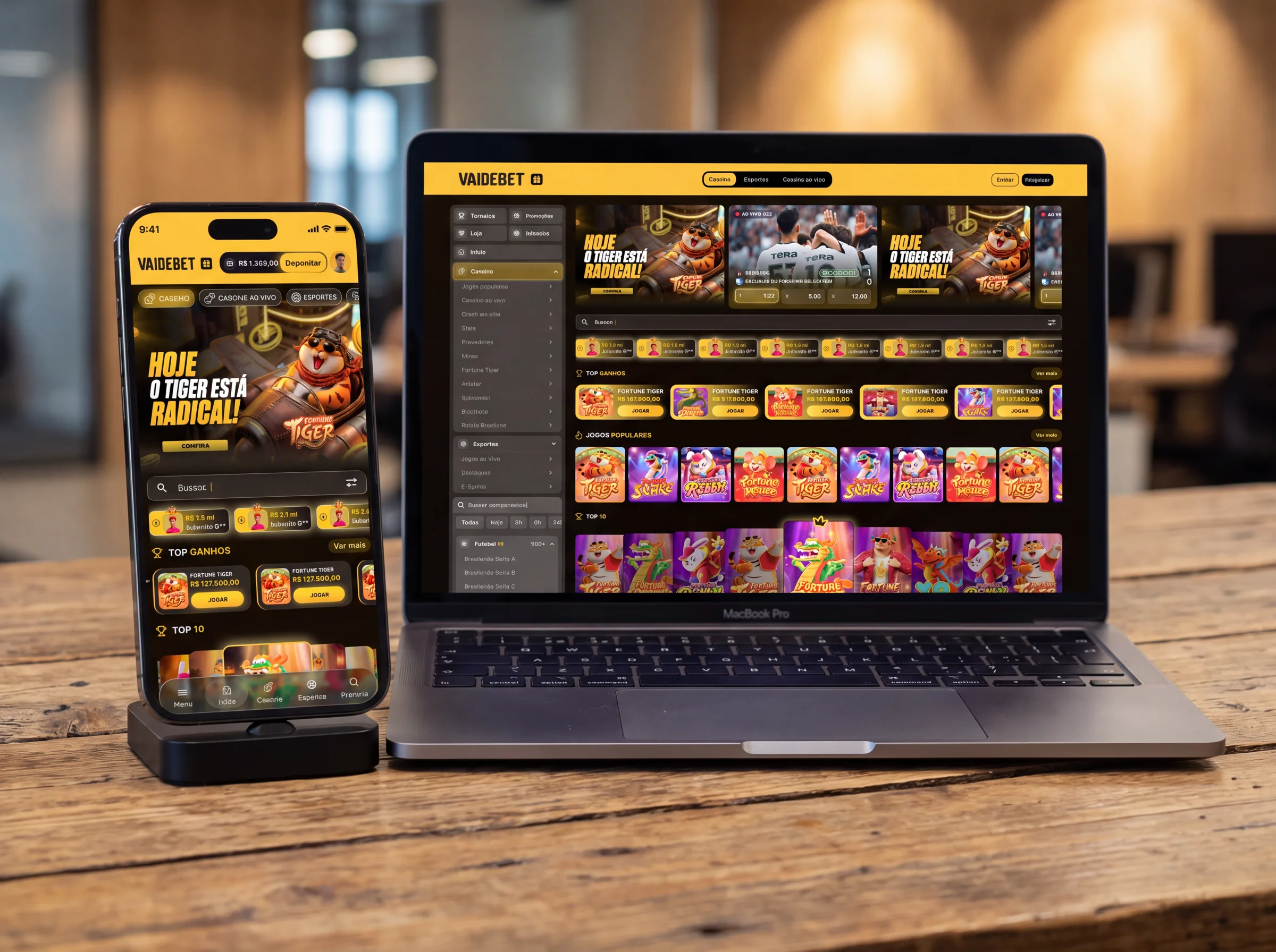 Mockup do VAIDEBET: home mobile num celular e home desktop num notebook, sobre uma mesa de madeira